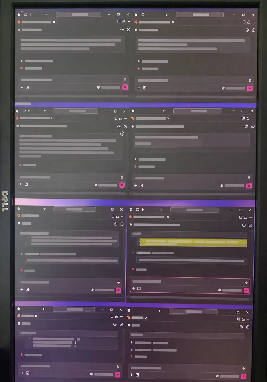 Redacted photograph of a monitor showing several parallel AI work sessions.